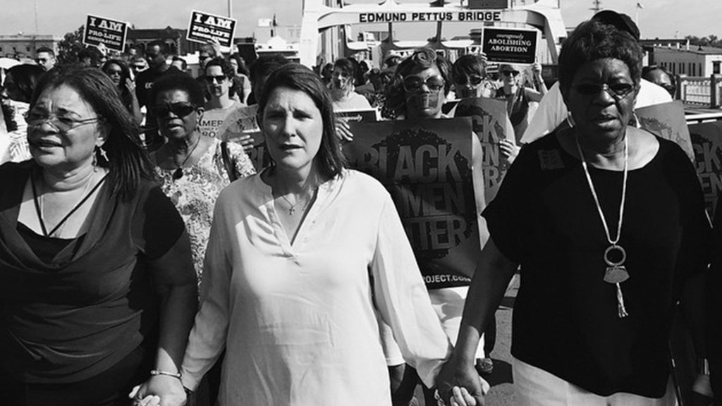 Catherine Davis leads march across the Edmund Pettus Bridge in The Selma Project